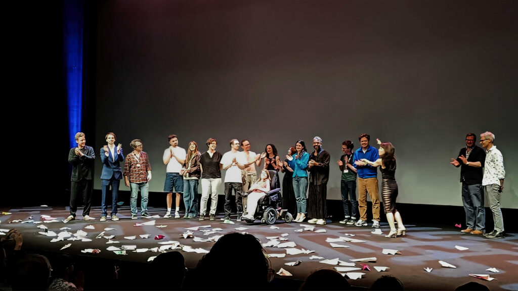 Team of the movie receiving applause from the audience